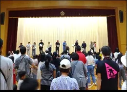 体育館の舞台に集まる参加者