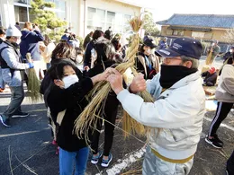 屋外でしめ縄づくりに取り組む参加者