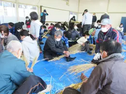 テーブルを囲んでしめ縄づくりに取り組む参加者